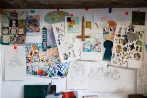 Picture of the interior of artist David Shillnglaw's studio in margate with drawings and paintings pinned to the wall.