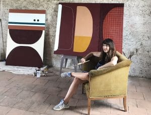 Portrait of Rachael McCully the australian artist in her studio next to large scale abstract canvasses