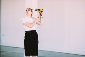 Image of a performance by artist Rosie Gibbens using a power drill