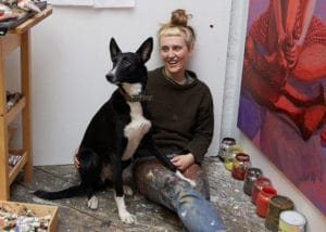 Portrait of artist and painter Nettle Grellier in her Stroud studio with dog